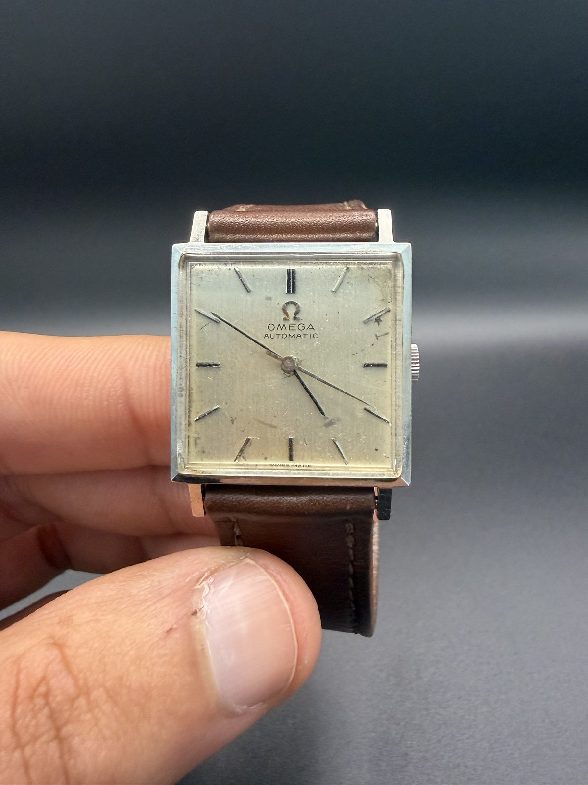 Omega Automatic square watch held in hand