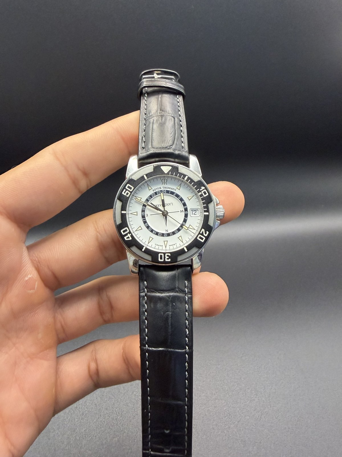 Revue Thommen Landmark on a black leather strap, held in hand