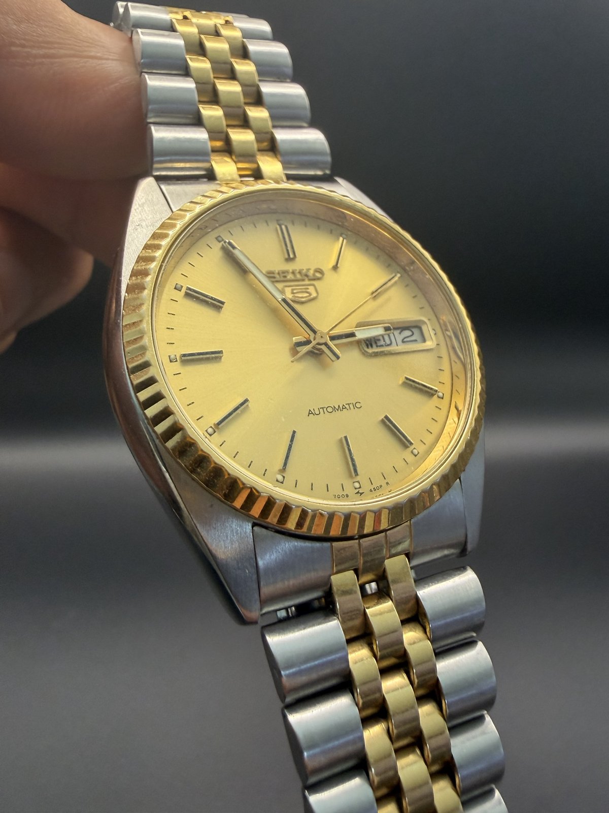 Angled view of the gold dial and fluted bezel