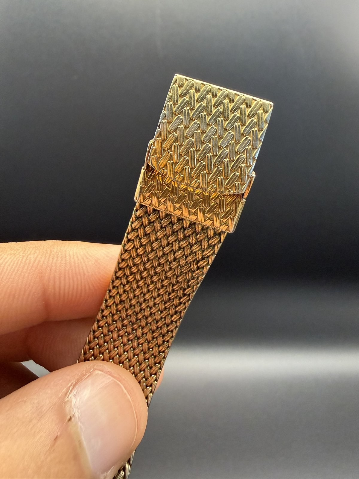 Close-up of the woven gold-tone mesh bracelet