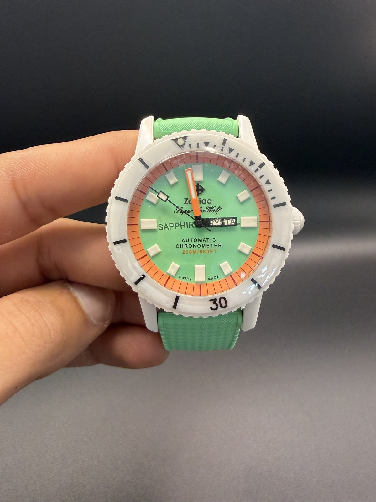Zodiac Super Sea Wolf with mint green and orange dial, held in hand