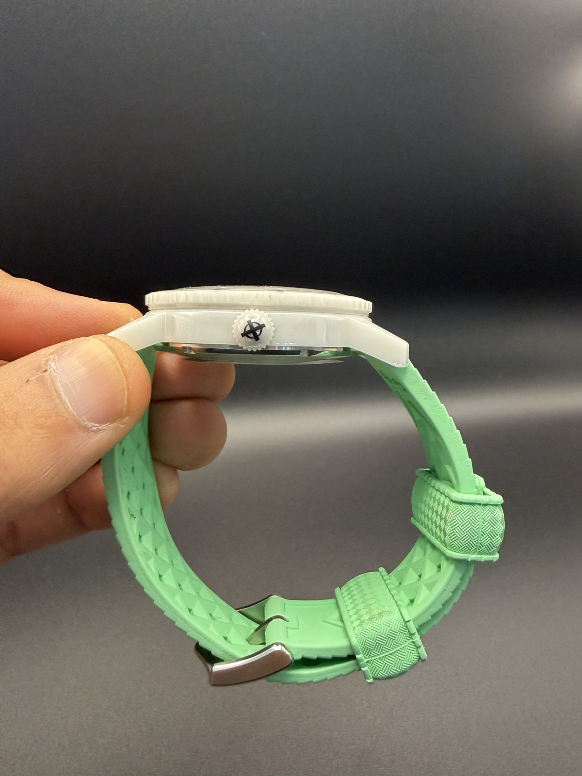 Side view of the white case and mint green rubber strap